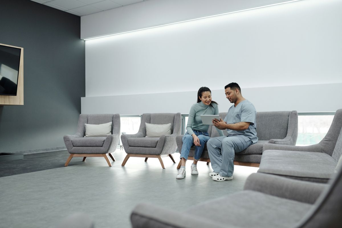 Clinician speaking with a patient in a modern clinic waiting area